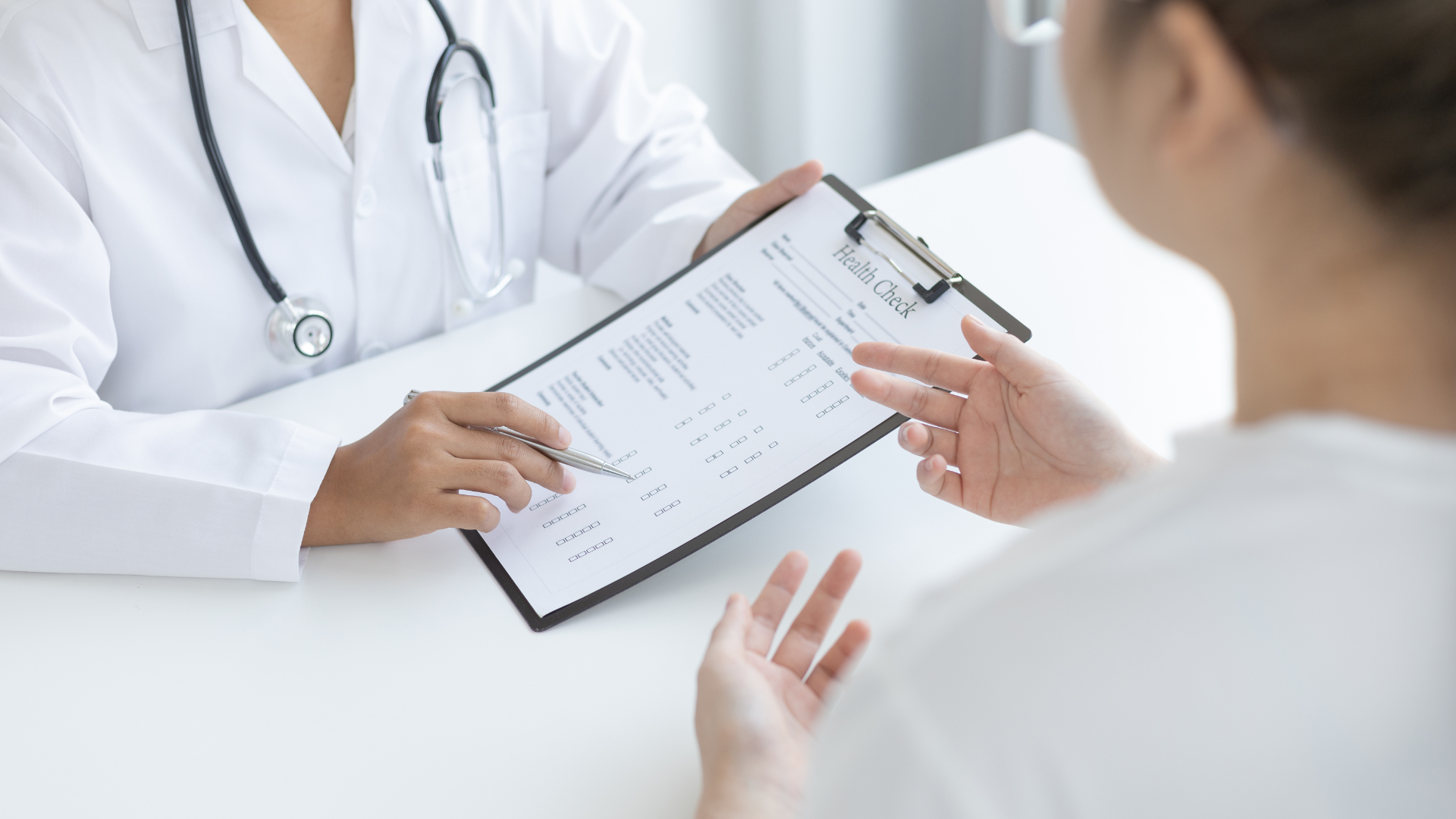 Woman talking to doctor on phone while sitting on her couch