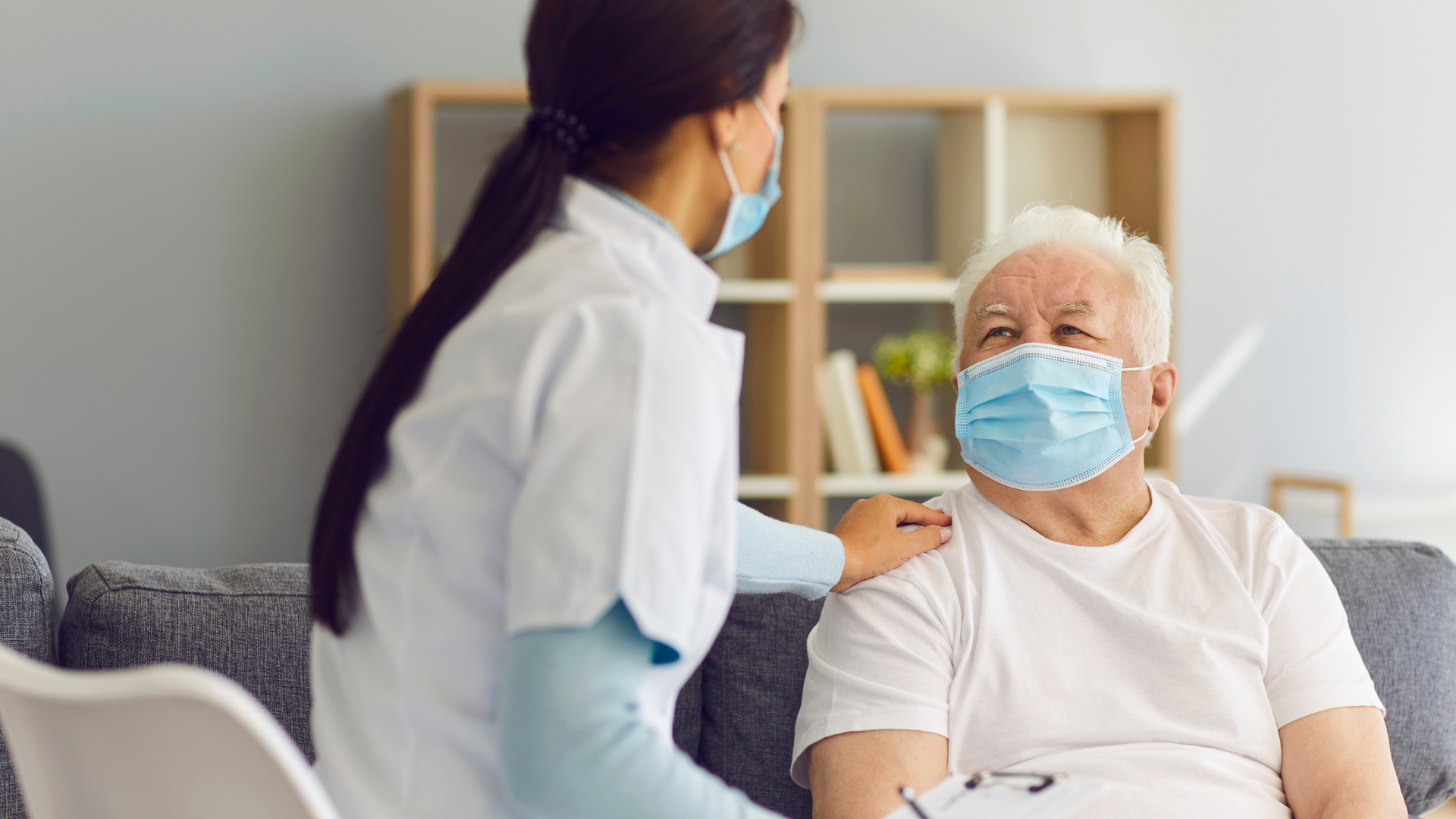 Woman sitting in break room talking to doctor on tablet